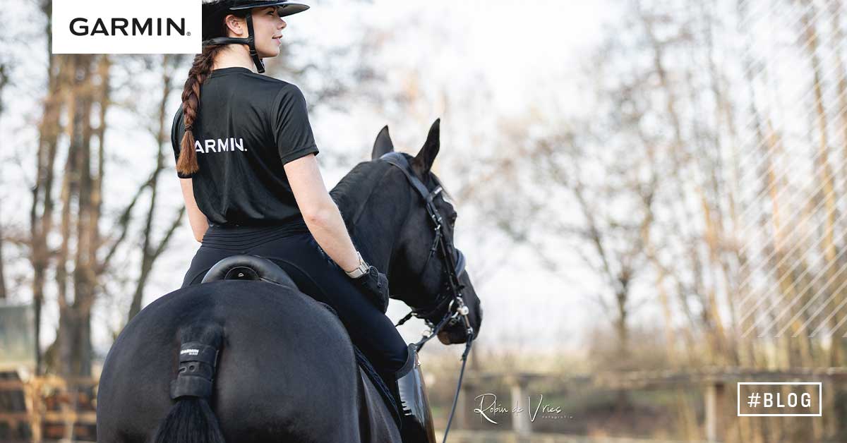 Febe Van Zwambagt på svart hest med Garmin Blaze-sensoren festet under haleroten